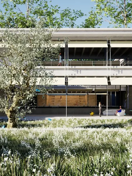 A view of the farmhouse from the garden, showing how the building is nestled within a field of wildflowers. The architecture is designed to be a backdrop for the natural landscape.