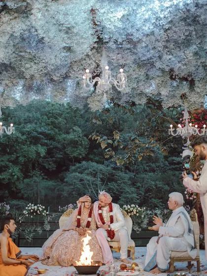 A magical ceremony setup under a dense canopy of white flowers and elegant chandeliers. The design created an enchanted forest feeling, providing a serene and romantic atmosphere for the couple's vows.