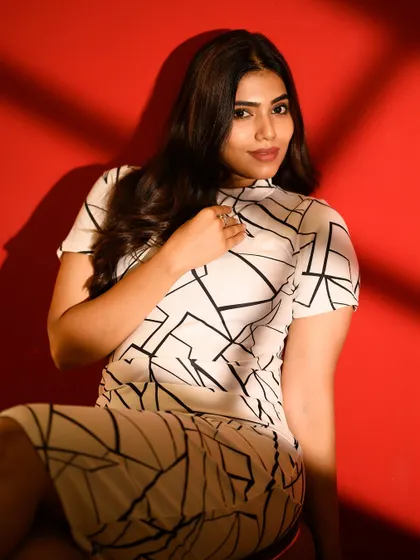 Using shadows from a window blind to create interesting patterns on the subject and the background. The red wall adds a pop of color and energy.