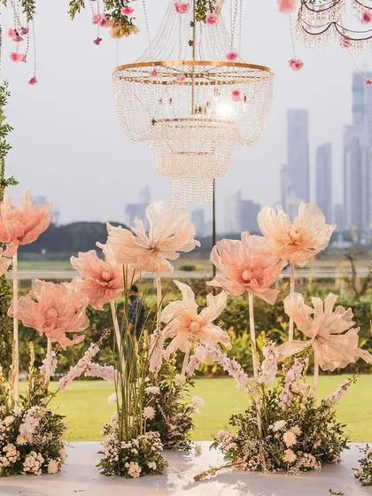 A detailed view of the mandap decor, focusing on the delicate, handcrafted paper flowers and the elegant birdcage-style chandeliers. Every element was chosen to create a soft, romantic, and picturesque setting.
