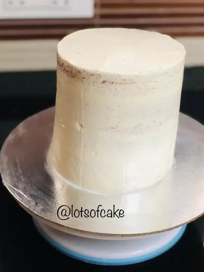 The crumb coat is a crucial first step for a professional looking cake. Here is a red velvet cake after its initial thin layer of frosting, ready for the final coat.