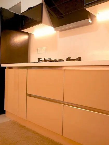 A parallel kitchen layout designed for efficiency, featuring light wood-look lower cabinets and white upper cabinets. The clean lines and under-cabinet lighting create a bright and functional corridor-style kitchen.