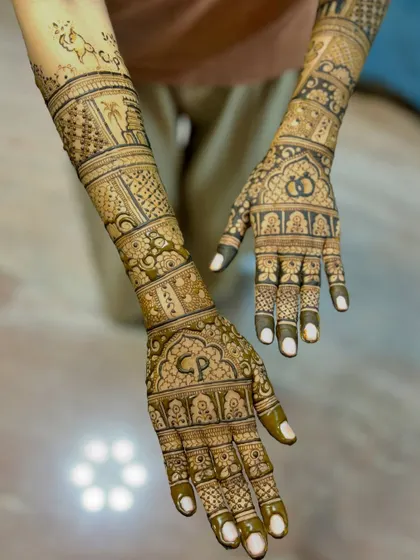 An engagement mehendi design featuring the couple's initials "CP" and interlocking rings, along with traditional elephant and architectural motifs.
