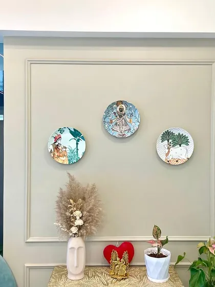 A close-up of the decorative wall plates and console table. These small, artistic touches are what give a room its unique character and charm.