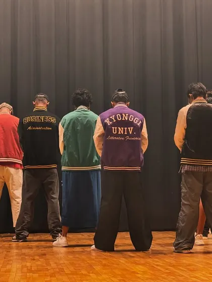 The calm before the storm. A group of performers with their backs to the audience, ready to turn around and kick off an unforgettable show.