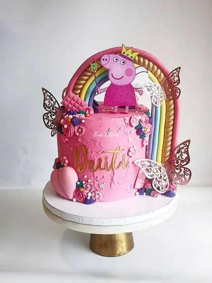 This isn't your usual Peppa Pig cake! We created a 'Princess Peppa' theme with a beautiful rainbow, butterflies, and lots of pink for a little girl's special day.