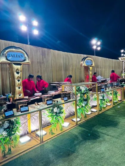 The elegant setup for my live Italian food station, featuring gold-accented counters and professional chefs in red uniforms.
