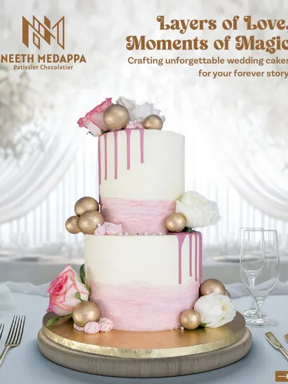 Layers of love, moments of magic. This two-tiered wedding cake combines a soft pink watercolor effect with a rich pink drip, adorned with white roses and golden spheres for a modern, romantic look.