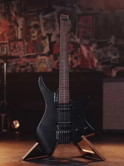 A full shot of the black Strandberg guitar, set against a rock-and-roll backdrop that matches its vibe.
