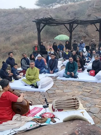 The audience sits in deep meditation, absorbed by the vibrations of the Rudra Veena in the heart of the restored quarry.