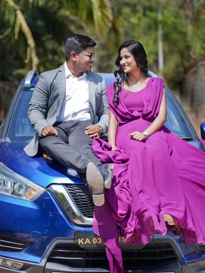 A stylish pre-wedding shoot featuring a couple posing on the hood of their car, combining modern style with a natural outdoor setting.