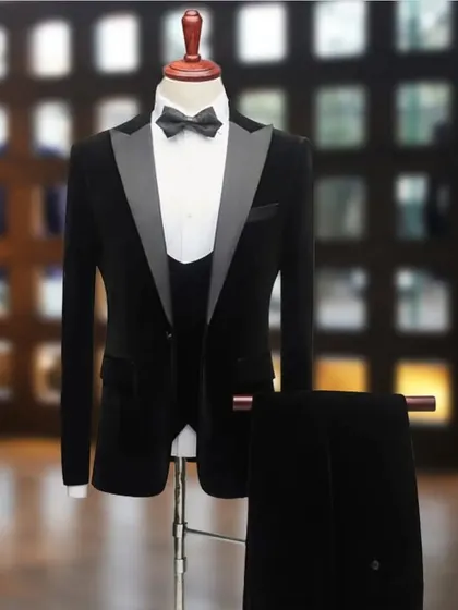 A black velvet tuxedo on a mannequin, showing the rich texture of the fabric. Velvet tuxedos are perfect for winter weddings and formal evening events.