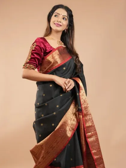 A timeless black silk saree with gold butis and a contrasting red and gold border. This is a must-have piece for its versatility and classic appeal.