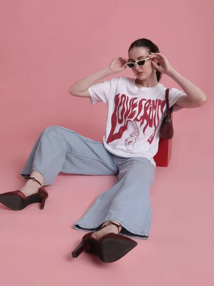 A relaxed yet put-together look featuring a 'Love Songs' graphic tee and wide-leg denim. The pointed heels elevate the casual outfit, making it suitable for a variety of urban settings.