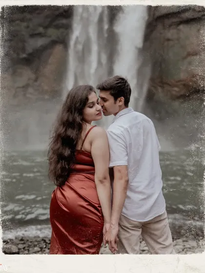 A vintage-edited photo of the couple sharing a tender moment by the cascading water.