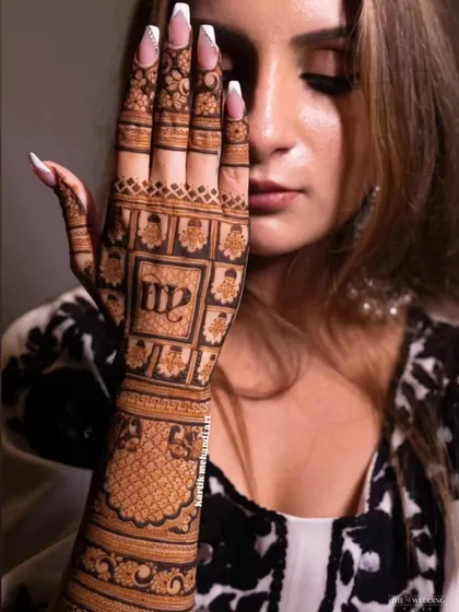 A modern back-hand design featuring the couple's initials 'MP' in a stylish font. This is a great way to personalize your mehandi.