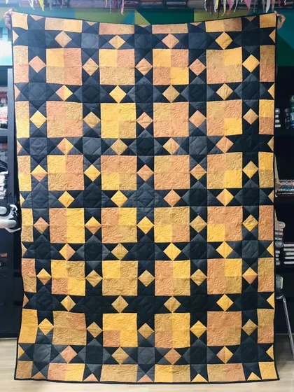 A Sawtooth Star memory quilt made from a client's suits. The rich, earthy tones of the suit fabrics create a sophisticated and handsome quilt.