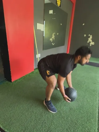 A client performs a medicine ball slam, a powerful exercise for developing explosive power and relieving stress.