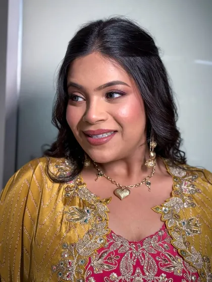 A side profile of the client, highlighting her soft glam makeup and heart-shaped necklace.
