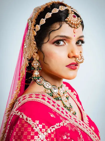 A detailed shot of the bride's expression and the stunning jewellery that pairs perfectly with the Marvadi lehenga.