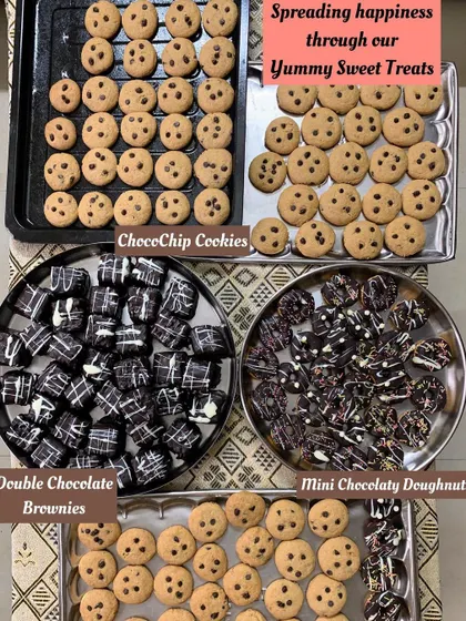 Spreading happiness with my sweet treats. Here are some of my homemade, eggless desserts including ChocoChip Cookies, Double Chocolate Brownies, and Mini Chocolatey Doughnuts, perfect for any celebration.