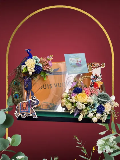 We also specialize in packing luxury accessories as part of the trousseau. Here, a Louis Vuitton bag is presented on a tray decorated with peacock feathers and colourful flowers for a Teej celebration.