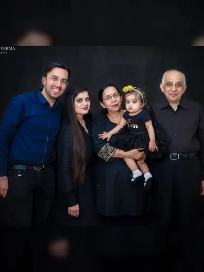 A precious multi-generational family portrait against a classic black backdrop. Capturing three generations together creates a priceless family heirloom.