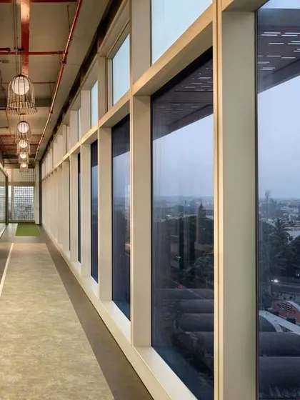 The corridor at CorporatEdge, Bangalore, which acts as a "street" connecting different work zones. The design uses glass walls and views to the outside to make circulation spaces feel open and engaging.