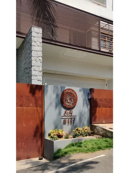The complete entrance composition, with the corten steel gate, custom signage, and a louvered screen above.