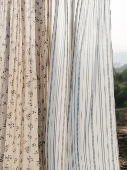 A close-up of our 'Pause' collection, showcasing the beautiful texture of our light-filtering sheers. Here, a floral pattern is paired with a misty blue stripe, both crafted from natural, breathable fabrics.