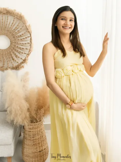 This portrait captures the pure joy and excitement of pregnancy, with a radiant smile that lights up the entire frame.