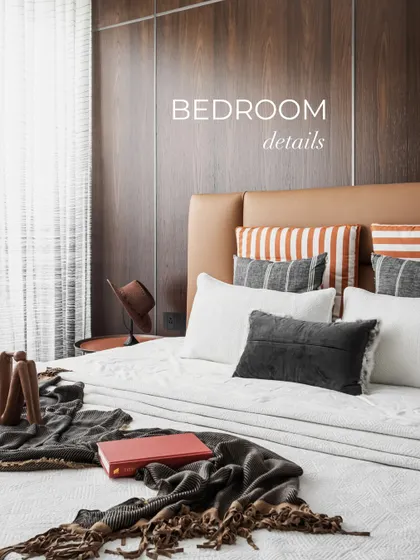 Every element in this bedroom is thoughtfully layered for function and finesse. A rich leather headboard is framed by deep-toned wooden panels with sleek metal inserts, adding warmth, contrast, and a touch of luxe.