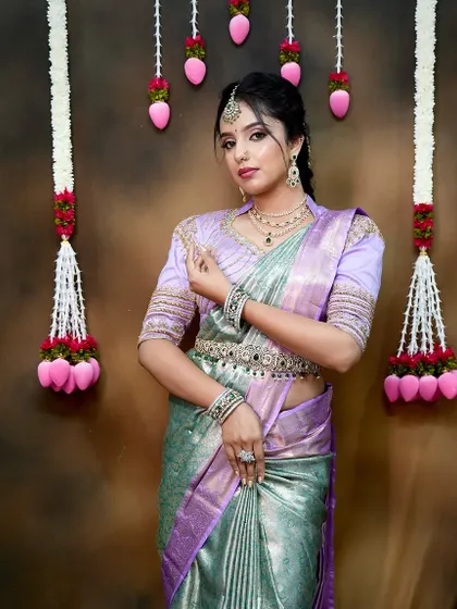 A full-length shot showcasing the entire look, including the delicate silver-and-green stone vaddanam that matches the necklace set.