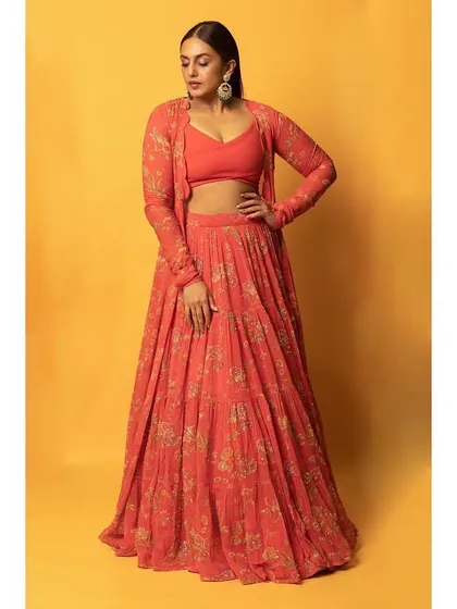 A vibrant and festive look for Huma Qureshi. This printed orange lehenga set by Paulmi and Harsh, complete with a matching jacket, is perfect for a daytime wedding event or mehendi.