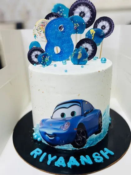 Another car-themed cake, this one for an 8th birthday, with a blue car and wheel toppers.