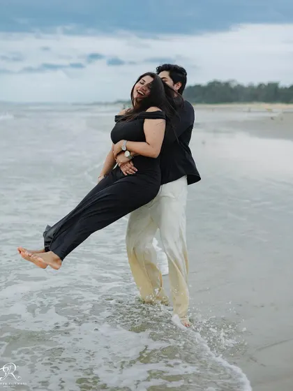A playful lift in the shallow waters of the Goan sea. This shot is full of fun and laughter, showcasing the carefree spirit of their relationship during this beach session.