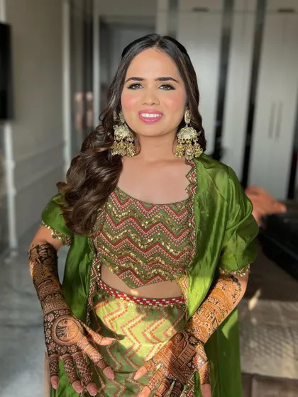 The complete Mehendi look, showcasing the intricate henna design. The fresh and glowing makeup ensures the bride looks and feels her best.