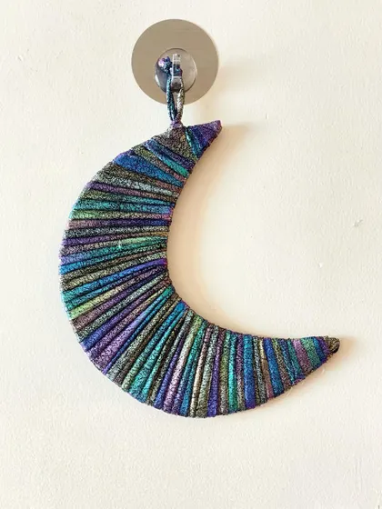 A shimmering crescent moon wall hanging. I used a special metallic, multi-colored cord to give this piece a magical, galaxy-like effect.