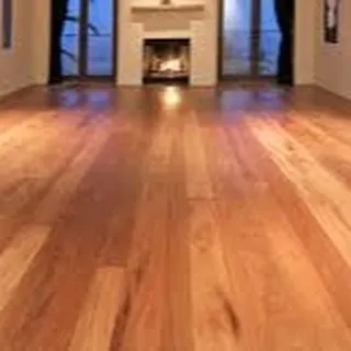 The high-gloss finish on this hardwood floor adds a touch of luxury to this empty room, highlighting its potential. This type of flooring is perfect for creating a dramatic first impression in an entryway or formal living space.