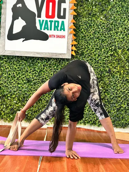 Using a strap to assist in Parivrtta Janu Sirsasana (Revolved Head-to-Knee Pose), this student works on deepening her side bend and hamstring stretch.