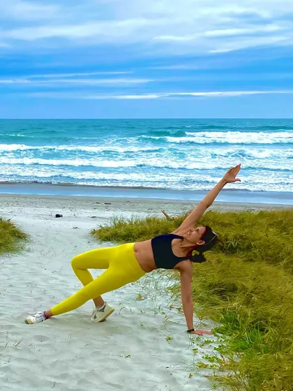 A beautiful shot of a member doing Pilates on the beach, embodying the freedom and joy of our #PilatesEverywhere philosophy.