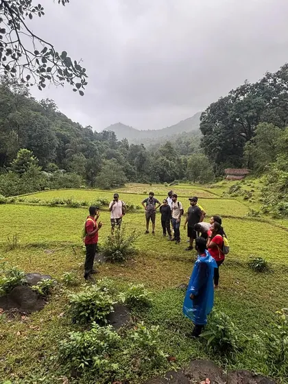 Another angle of our group briefing, showing the vast green landscape that awaits us. These open fields surrounded by forests are a common and beautiful sight on our treks.