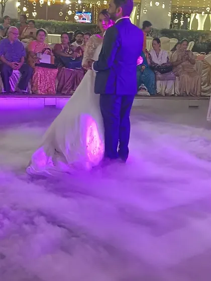 A couple shares their first dance enveloped in purple-lit fog, a special effect we can arrange for a dramatic reception entry.