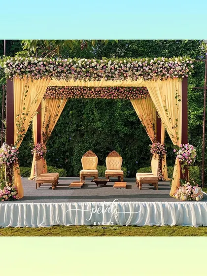 This contemporary mandap is a fusion of vibrant colors and classic design. Assorted roses in every shade adorn the structure, while stunning yellow fabric adds a celebratory touch to the scene.