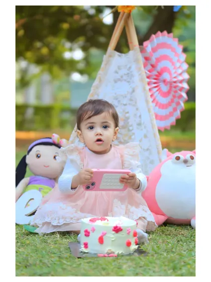 An outdoor cake smash session with a cute pink and white picnic theme.