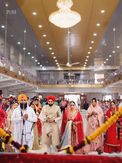 The couple during the Laavan Pheras, a central part of the Sikh wedding ceremony. This shot captures the movement and tradition of the moment.