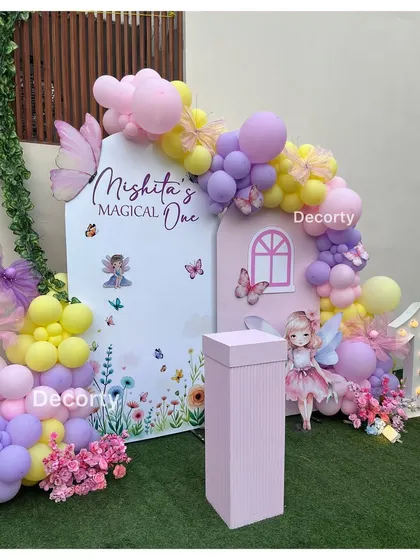 A close-up of the fairy-themed backdrop, showing the personalized "Mishita's Magical One" sign and beautiful balloon work.