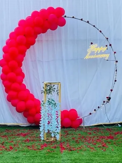 A passionate red version of the modern anniversary backdrop. The vibrant red balloon crescent makes a bold statement against the white background and green lawn.