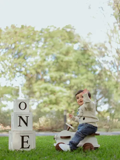 The birthday boy gives a happy wave to the camera during his outdoor session.