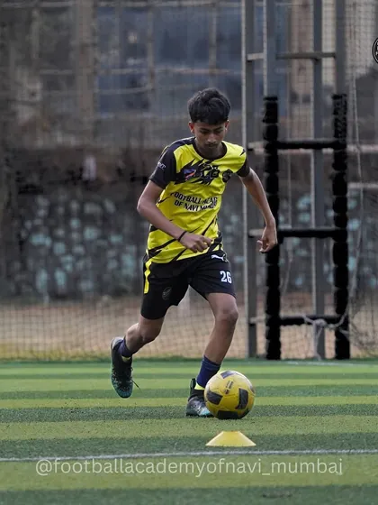 A player dribbles around a cone, a classic drill for improving close control and agility. These foundational exercises are a staple in our sessions.